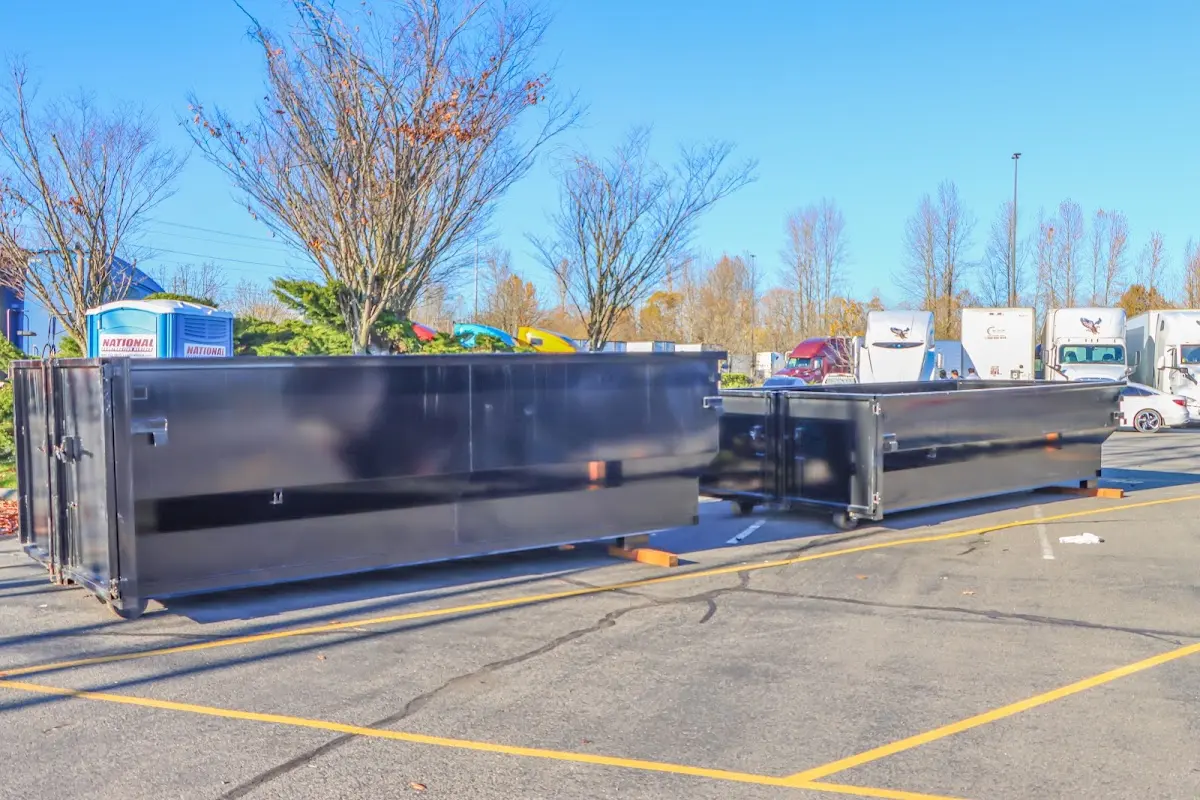 Professional dumpster rental service with roll-off container on residential driveway in Hudson